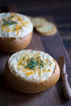 two bread bowls filled with cheese and crackers