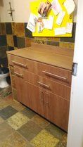 a bathroom with a toilet and wooden cabinets