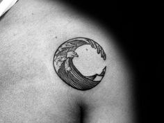 a black and white photo of a man's chest with a wave tattoo on it