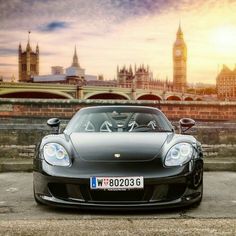 a black sports car parked in front of the big ben clock tower