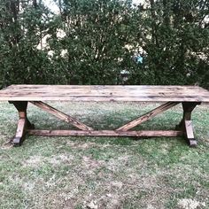 a wooden table sitting on top of a lush green field