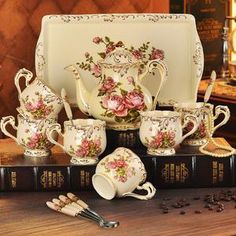 the tea set is decorated with pink flowers