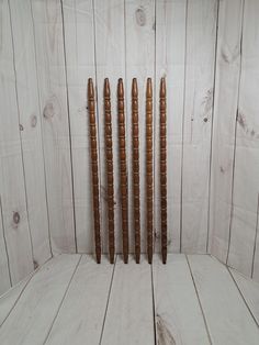 four wooden candles lined up against a white wall