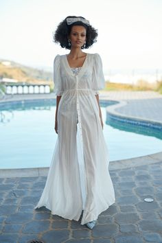 Vacation to a bygone era with The Ivory Sunroom Cover-Up, a dreamy maxi-length cotton gauze dress that embodies the carefree spirit of the Côte d'Azur. The center-front hidden snap closures create a sleek and uninterrupted flow, while the mid-length puff sleeves, cinched with elastic cuffs, add a playful and feminine flair. Reminiscent of the iconic dressing gowns in Valley of the Dolls, this is the perfect beach coverup for those seeking a blend of old-school prestige and modern refinement. Sty Spring Cotton Gauze Maxi Dress For Daywear, Spring Daywear Cotton Gauze Maxi Dress, White Sheer Maxi Dress For Daywear, Cotton Gauze Dress, Silk Dressing Gown, Corset Skirt, Skirt Swimsuit, Puff Dress, Dressing Gowns