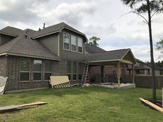 a house that is under construction with the roof ripped off and some tools laying on the grass