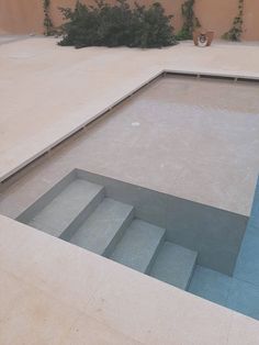 an empty swimming pool with steps leading up to it