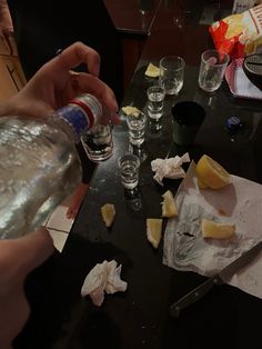 someone is cutting up pieces of cheese with a knife and some glasses on the table