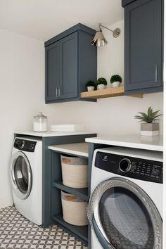 a washer and dryer in a laundry room with blue cabinets, checkered floor