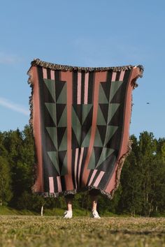 a person standing under a large blanket in the grass with their feet on one leg