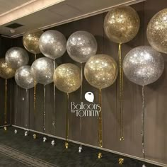 balloons and streamers are lined up against the wall in an office lobby for a party