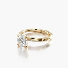 a yellow gold engagement ring with a single diamond in the center, on a white background