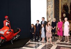 a group of people standing in front of a red motorcycle