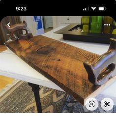 a wooden board sitting on top of a table next to a pair of ironing tongs