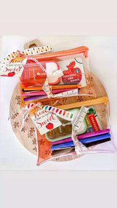 several pencils and markers are on a wooden tray with ribbon around it, along with other school supplies