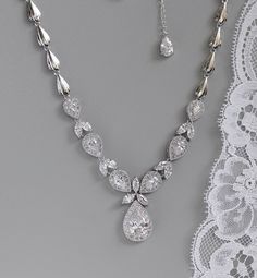 "Stunning teardrop crystal necklace has been designed with marquise cut crystals in between teardrop crystal zircons set in halos of tiny crystals creating a statement necklace in true Hollywood style. The upper band has been made with coordinating shell shaped links to create a comfortable and light necklace to wear. An 1.5\" extender chain with a pretty crystal drop is optional. Measures: L = 17\" (43 cm) approx High quality zircon crystals set in tarnish free rhodium. Highest quality cubic zi Silver Pear-shaped Bridal Necklace, Dazzling Teardrop Pendant Diamond Necklace For Wedding, Crystal Teardrop Pendant Necklace For Anniversary, Dazzling Teardrop Diamond Necklace For Weddings, Diamond White Teardrop Pendant Necklace For Wedding, Dazzling Teardrop Cubic Zirconia Necklace, Teardrop Crystal Drop Necklace For Anniversary, Crystal Teardrop Drop Necklace For Anniversary, Pear-shaped Crystal Necklaces With Diamond Accents