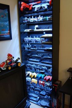 a room filled with lots of toy cars and toys on top of shelves next to a tv