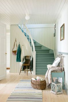 a room with a stair case and rug on the floor