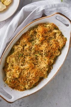 an oval casserole dish filled with broccoli, cheese and parmesan