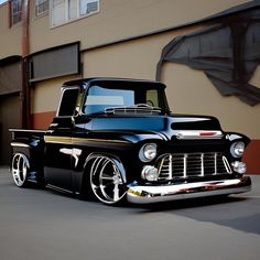 an old black truck parked in front of a building