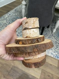 a person holding a piece of wood in their hand and stacking it on top of each other