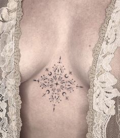 a woman's chest with an intricate tattoo design on her left side ribcage