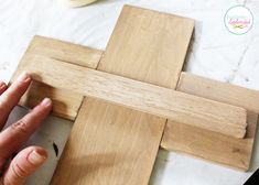 someone is making a cross out of wood