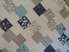 a close up of a patchwork quilt on a table top with blue and gray squares