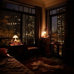 a dimly lit bedroom with city lights in the window