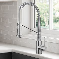 a kitchen faucet that is on the side of a sink in front of a window