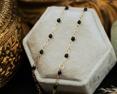 From our Color Romance Collection, this black enamel beaded piatto chain will add a pop of color to any outfit. Crafted in 14K gold, this 1 inch adjustable chain secures with a spring ring. NECKLACE DETAILS: Length: 7.5 Inches Millimeter: 1.7 Gauge: 030 Average Weight (g): 0.73 Closure: 5.0m Spring Ring Available in 14K Yellow Gold ***These necklaces have a 4 week lead time. If you need your necklace sooner than that, please contact us prior to ordering to verify if that's possible.*** | Black Enamel Bead Piatto Chain Bracelet In 14K Yellow Gold Ring - by Staghead Designs - Unisex Staghead Designs, Enamel Beads, Average Weight, Ring Fit, Black Enamel, Lead Time, Yellow Gold Rings, Spring Rings, Ring Necklace