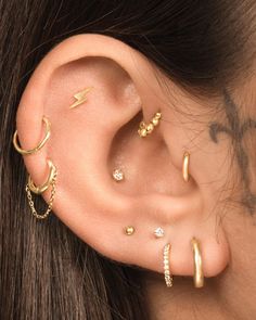 a woman wearing three different ear piercings