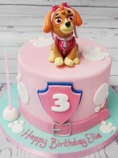 a pink birthday cake with a dog on it's top and the number three