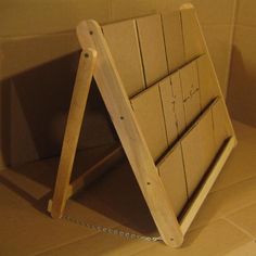 a wooden rack with several boards attached to it on the floor in front of a tiled wall