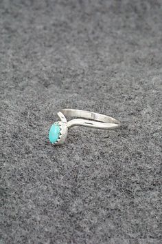 This simple yet elegant turquoise and sterling silver ring was made by Navajo silversmith Hiram Largo. The inside of the band is stamped sterling. (Please note: the stone color may vary slightly from the photos.)Size: 9.5Stone Length: 1/4"Stone Width: 3/16"Free shipping on all orders! We ship with USPS and always include tracking. All orders ship within a day of payment.Returns are accepted up to 30 days after you receive your order. Just send us a message. Our shop offers cash back or store credit. The item must be returned in new condition. Silver Turquoise Birthstone Ring For Anniversary, Turquoise Birthstone Ring In Sterling Silver, Sterling Silver Turquoise Ring As Birthstone, Turquoise Sterling Silver Opal Ring For Promises, Sterling Silver Turquoise Opal Promise Ring, Turquoise Sterling Silver Promise Ring, Sterling Silver Turquoise Ring, Oval Promise Ring, Turquoise Opal Promise Ring In Sterling Silver, Oval Turquoise Ring In Sterling Silver For Promise