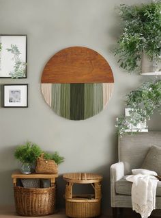 a living room with some plants and pictures hanging on the wall, along with two wicker baskets