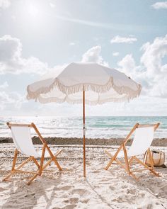 two chairs and an umbrella on the beach