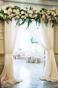 an elegant wedding ceremony with flowers and draping on the windowsills is ready for guests to arrive