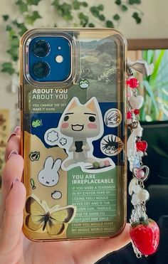 a person holding up a phone case with an image of a cat and other animals on it