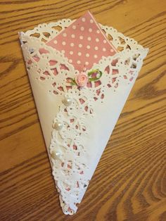 a piece of paper that is on top of a wooden table with lace and flowers