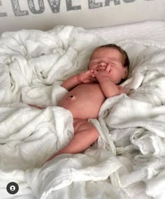 a baby is laying down on a white blanket with the words live laugh love laugh