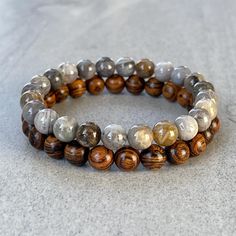 Men's beaded bracelet made with strong, stretchy cord and genuine/natural gemstones and wood. Features ~ 6mm/8mm/10mm tiger skin sandalwood beads ~ 6mm/8mm/10mm bamboo leaf agate ~ Stretchy cord; simply slide bracelet on and off wrist ~ Comes packaged in a re-usable microfiber pouch To ensure the perfect fit, please use the bracelet sizing instructions found in the photo gallery. Refund Policy: Items can be returned for refund (less shipping costs) within 14-days.  All items must be in new/unworn condition.  If items are not returned in new/unworn condition, they will be sent back at buyer's expense. Bamboo Leaf, Tiger Skin, Slide Bracelet, Bamboo Leaves, Onyx Bracelet, Mens Beaded Bracelets, Agate Bracelet, Lava Bead, Onyx Bead