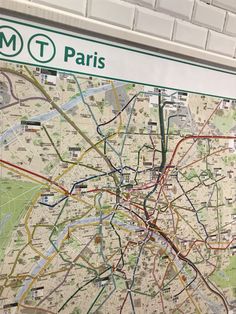 a subway map is hanging on the wall in front of a sign that says metro paris