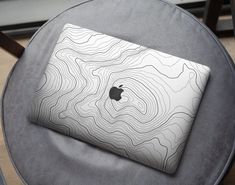 an apple laptop sitting on top of a gray chair