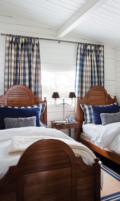 two beds in a room with blue and white curtains