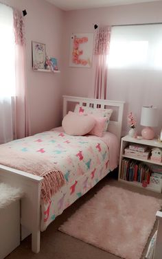 a bedroom with pink walls and white bedding, carpeted flooring and window curtains