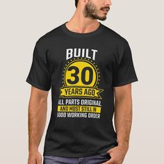 a man wearing a black shirt that says built 30 years ago