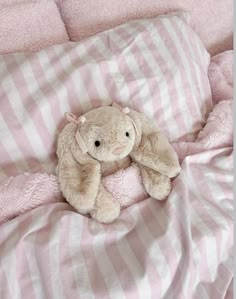 a stuffed animal laying on top of a bed