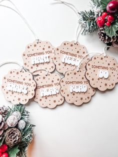 six wooden tags that say something you hope to do next to some pine cones and berries