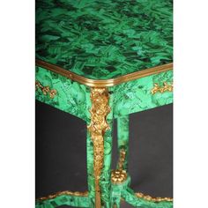 an ornate green table with gold trimming