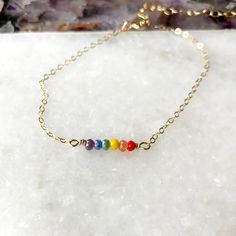 a rainbow of small (4mm) faceted glass beads adorns this simple 6-8" chain bracelet. Includes a 2" adjustable chain. Pride Bracelet, Faceted Glass, A Rainbow, Bracelet Sizes, Delicate Bracelet, Chain Bracelet, Gold Filled, Glass Beads, Rose Gold